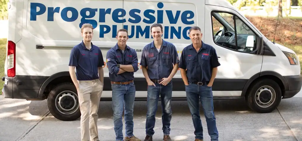 Progressive plumbing technicians in front of one of their plumbing vans